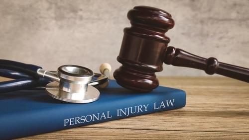 Personal Injury Lawyer at Altman-Nussbaum-Shunnarah Trial Attorneys with gavel resting on personal injury law book and stethoscope