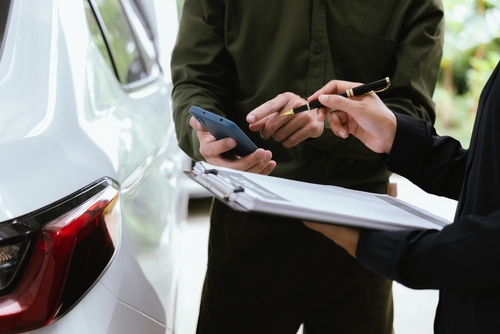 Car accident lawyer at Altman-Nussbaum-Shunnarah Trial Attorneys reviewing vehicle damage and insurance documents after crash.