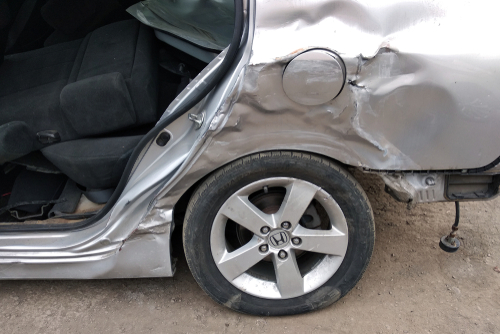 Car accident lawyer at Altman-Nussbaum-Shunnarah Trial Attorneys reviewing severe side-impact vehicle damage after crash.