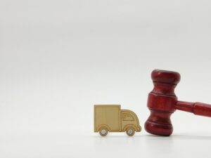Boston Truck Accident Lawyer reviewing commercial truck liability with gavel and delivery truck model.